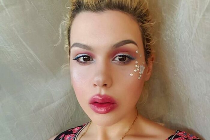 Amber wears face jewels and colorful makeup.