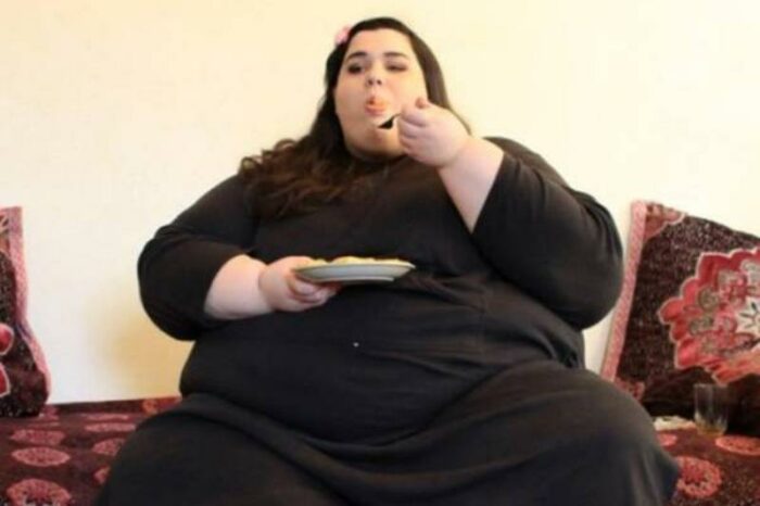 Amber takes a bite of food while sitting on the couch.